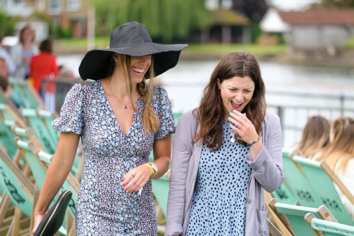 Two ladies laughing whilst walking at Henley Royal Regatta