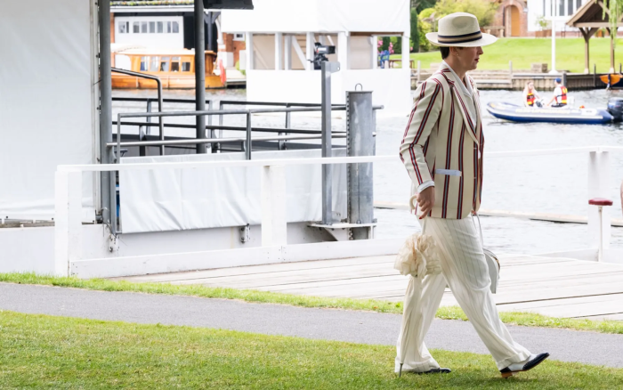 A lady in striped trouser suit in the Stewards' Enclosure at Henley Royal Regatta